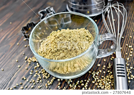 Flour hemp in glass cup with mixer on dark board Flour hemp in glass cup with mixer on dark board 27807648