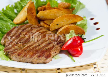 Steak is on the leaves of lettuce 27811435
