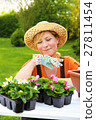Young woman planting flower seedlings, gardening 27811454