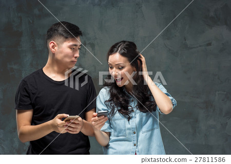 Asian young couple using cellphone, closeup 27811586