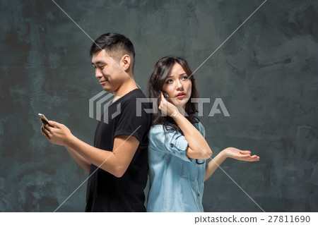 Asian young couple using cellphone, closeup Asian young couple using cellphone, closeup 27811690