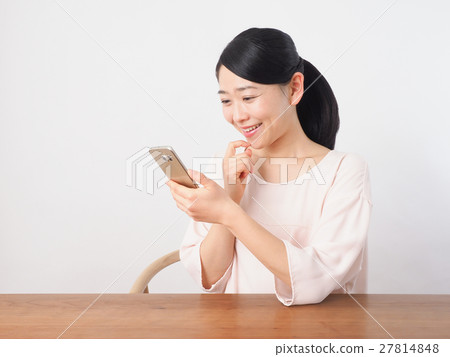 一個女人看著金的智能手機 一個女人看著金的智能手機 27814848