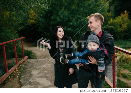 young family and son walk along the lake shore 27816957