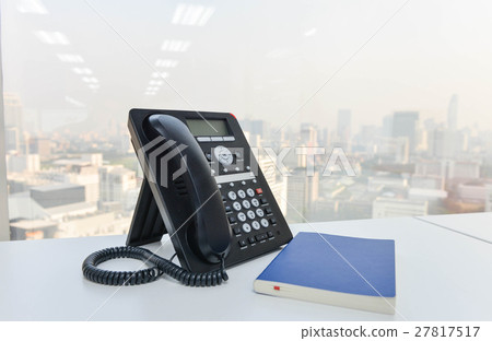 IP Phone and blue notebook on the white table 27817517