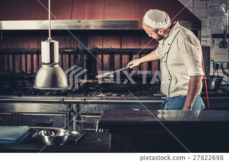 Busy chef at work in the restaurant kitchen 27822698
