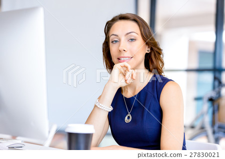 Young businesswoman sitting at desk and working 27830021