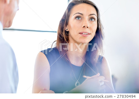 Young businesswoman sitting at desk and working Young businesswoman sitting at desk and working 27830494