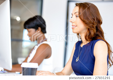 Portrait of businesswoman working at her desk in office Portrait of businesswoman working at her desk in office 27831291
