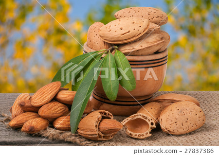 almonds with leaves in a bowl on the old wooden almonds with leaves in a bowl on the old wooden 27837386