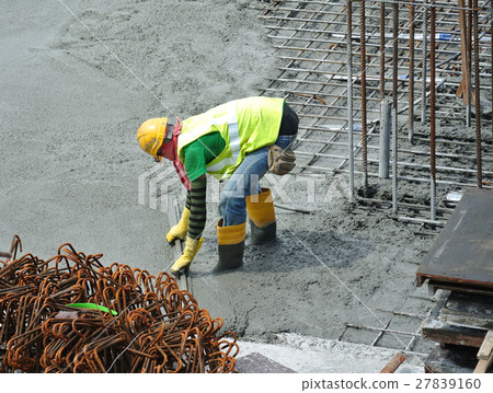 Construction workers leveling wet concrete Construction workers leveling wet concrete 27839160