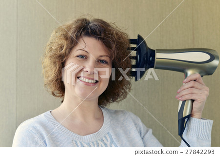 Woman doing curls with hairdryer and diffuser Woman doing curls with hairdryer and diffuser 27842293