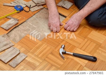 Man Removing Damaged Parquet in Apartment Man Removing Damaged Parquet in Apartment 27847981