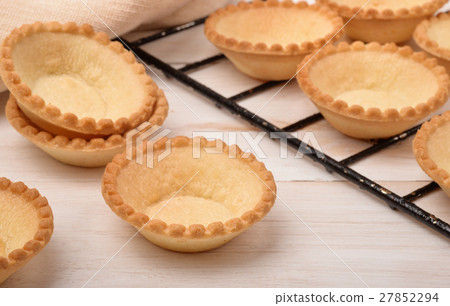 Group of fresh baked empty tart shells Group of fresh baked empty tart shells 27852294