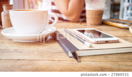 Mobile phone and diary notebook with coffee cup on wood background, selective focus Mobile phone and diary notebook with coffee cup on wood background, selective focus 27860531