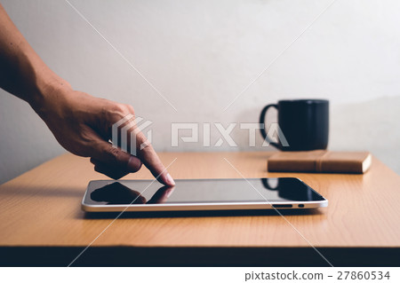 Smartphone or tablet computer male hand touching screen, vintage filter effect Smartphone or tablet computer male hand touching screen, vintage filter effect 27860534