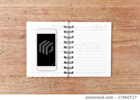 Top view of Open Notebook and smart phone on wood table for background Top view of Open Notebook and smart phone on wood table for background 27860717