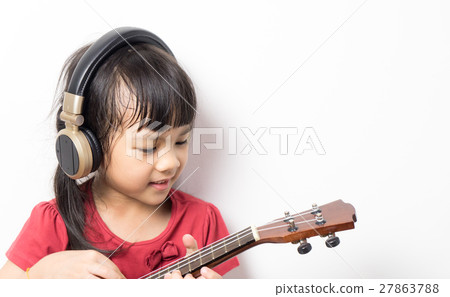 Asian girl is practicing guitar wearing headphone Asian girl is practicing guitar wearing headphone 27863788