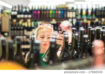 Woman shopping groceries at supermarket. 27866549