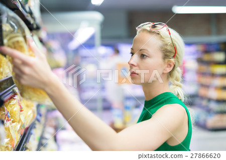 Woman shopping groceries at supermarket. 27866620