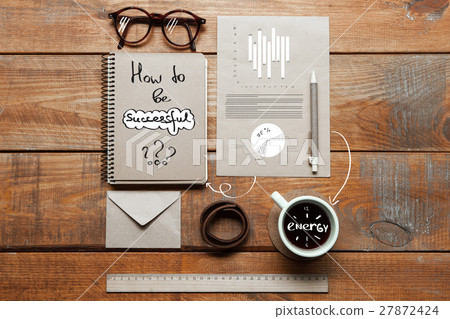 Notebook, coffee cup, glasses and pen on table Notebook, coffee cup, glasses and pen on table 27872424
