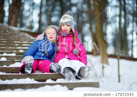 Two adorable little sisters having fun in winter 27872593
