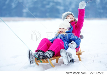 Two cute little sisters having fun in winter park 27872595
