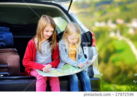 Two adorable little sisters exploring a map Two adorable little sisters exploring a map 27872596