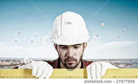 Builder checking spirit level 27877898