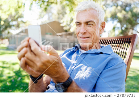 LoMature man outdoors using mobile phone LoMature man outdoors using mobile phone 27879735