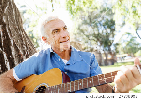 Senior man plying guitar outdoors Senior man plying guitar outdoors 27879905