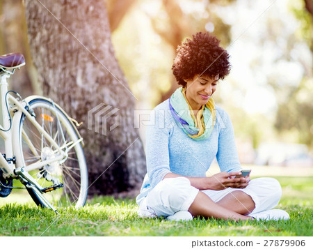 Charming young woman in summer park with mobile 27879906