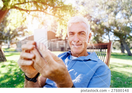LoMature man outdoors using mobile phone 27880148