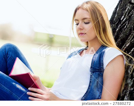 Beautiful young woman writing in her diary outdoors Beautiful young woman writing in her diary outdoors 27880272