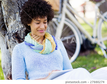 Young woman using tablet in the park. Young woman using tablet in the park. 27880274