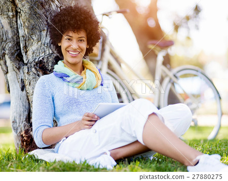 Young woman using tablet in the park. 27880275