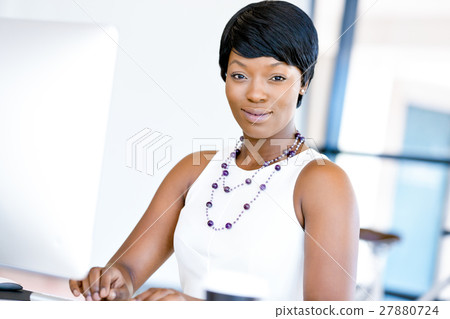 Portrait of businesswoman working at her desk in office 27880724