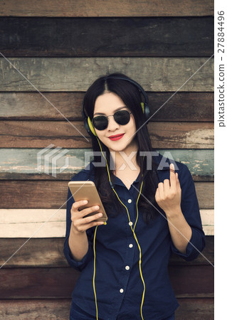 happy asian woman listening to music on headphone 27884496