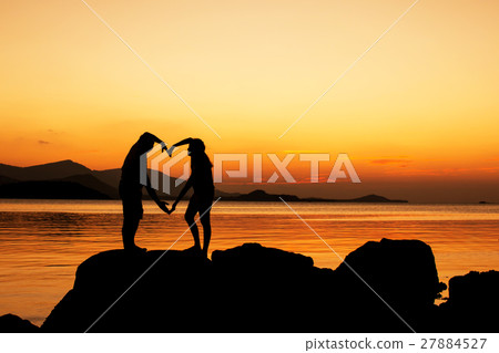 Silhouette of young couple in love at beach Silhouette of young couple in love at beach 27884527