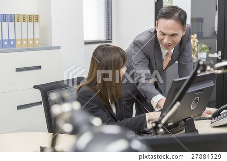 Boss and female employees who work while watching a computer Boss and female employees who work while watching a computer 27884529