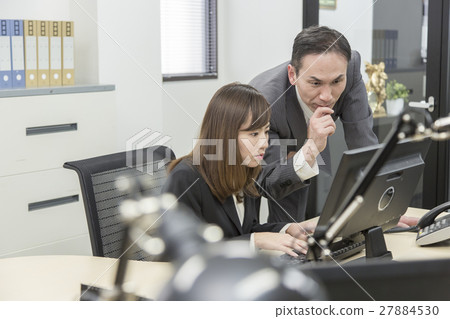Boss and female employees who work while watching a computer Boss and female employees who work while watching a computer 27884530