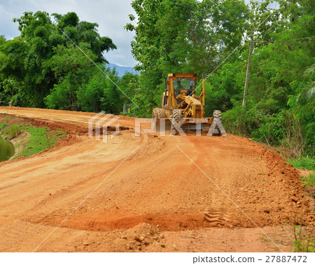 large grader  a narrow rural road 27887472
