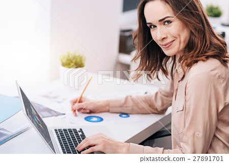 Cheerful young businesswoman working in the office 27891701