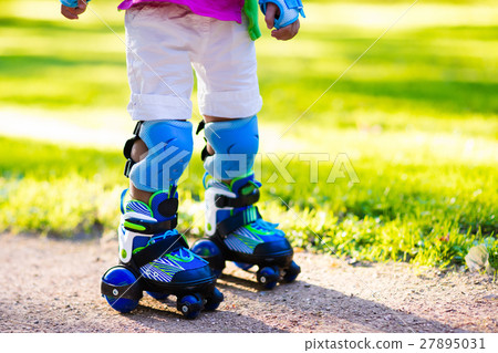 Kids roller skating in summer park 27895031