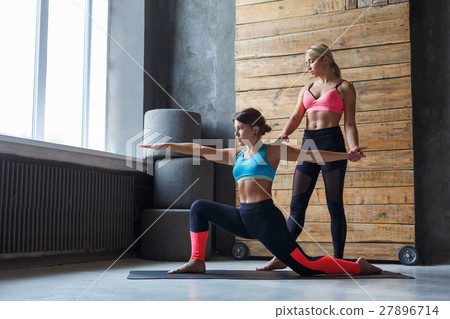 Young woman with yoga instructor in fitness club Young woman with yoga instructor in fitness club 27896714