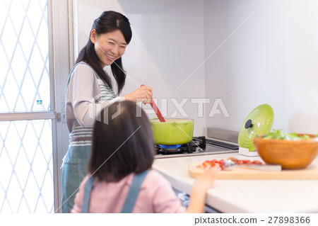 A girl who helps with a mother who cooks in the kitchen 27898366