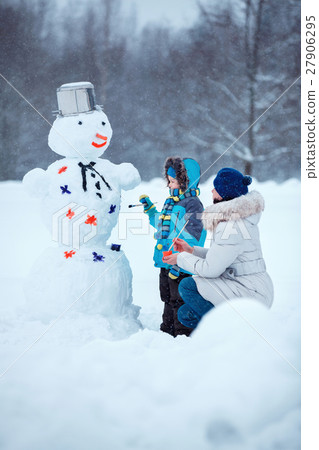 Little boy with his mother painting a snowman Little boy with his mother painting a snowman 27906295