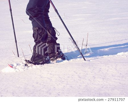 Man legs with snowshoes walk in snow. Detail  27911707
