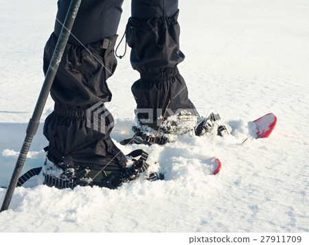 Man legs with snowshoes walk, winter hike 27911709