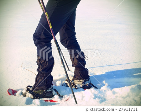 Man legs with snowshoes walk in winter snowdrift Man legs with snowshoes walk in winter snowdrift 27911711