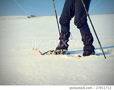 Man legs with snowshoes walk in  winter hike 27911712